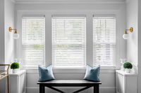 Classic white faux wood blinds, offering a durable and stylish replica of real wood for light control and privacy.