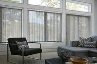 Vertical blinds made of custom fabric for sliding glass doors provide privacy and a modern living room .